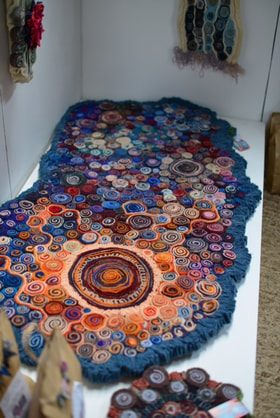 'Sunburst' very large quillie rug in blues, oranges and pinks.